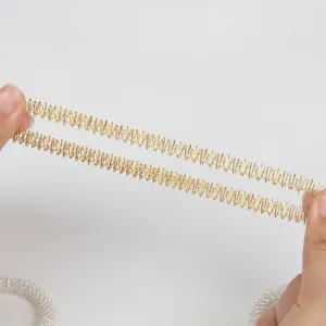 Vue détaillée d'anneau de massage à ressort extensible doré et argenté, jouet anti-stress.