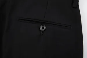 Λεπτομερές κοντινό πλάνο της πίσω τσέπης μαύρου ανδρικού παντελονιού με κουμπί.