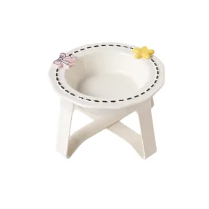 Elevated ceramic pet bowl with cute bow and star decor, dashed rim design for pets.