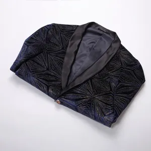 Vista detallada de la chaqueta de terciopelo azul con patrón geométrico dorado y solapa.