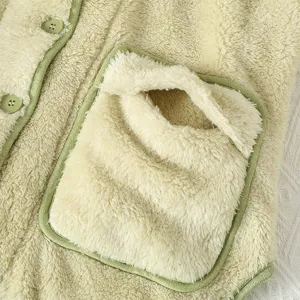Dettaglio del pigiama in pile sherpa soffice, comoda loungewear calda con tasca e bordo verde.