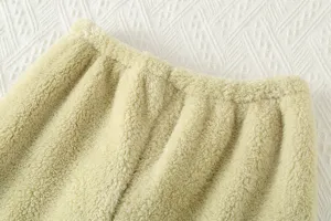 Dettaglio pantaloni pigiama in morbido pile spesso, tessuto per abbigliamento da casa invernale caldo.