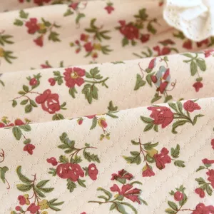 Détail du tissu matelassé floral de chemise de nuit d'hiver pour femme avec col en dentelle.