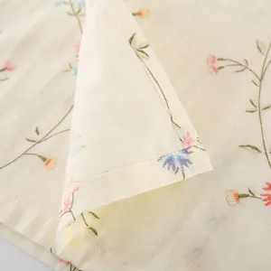 Close-up of soft cotton gauze sleepwear fabric, delicate floral pattern and fine stitching detail.