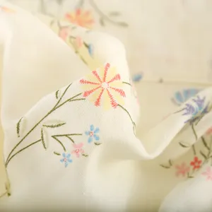 Close-up detail of soft cotton gauze fabric featuring delicate floral print and gentle folds.
