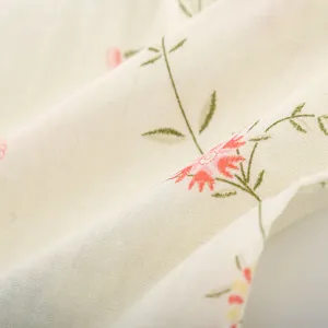 Close-up detail of soft cotton gauze fabric featuring delicate floral print for comfortable sleepwear.