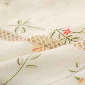 Close-up of soft cotton gauze kimono fabric with delicate floral print and lace trim.