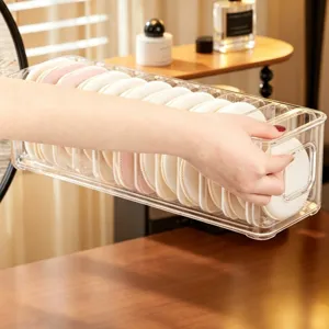 Clear acrylic makeup puff storage box with multi-compartments for desktop cosmetic organization.