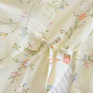 Cotton floral pajama detail close-up, soft yellow kimono robe fabric tie and print texture.