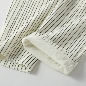 Detailopname van gestreepte gewatteerde lucht-katoenen stof, zachte textuur voor herfst pyjamabroek.