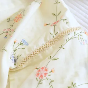 Close-up detail of soft cotton pajama fabric with vintage floral print and delicate lace trim.