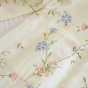 Cotton pajama detail shot featuring cute floral embroidery and pocket design. Soft and comfortable fabric.