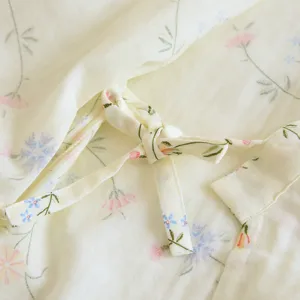 Close-up detail view of women cotton pajama tie knot and soft floral print fabric.