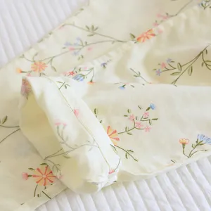 Close-up detail of soft cotton loungewear with delicate floral print and neat hem stitching.