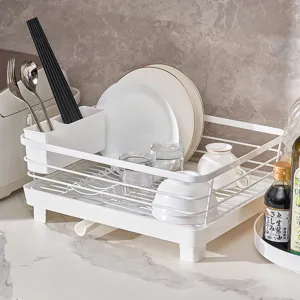 White kitchen dish drying rack with utensil holder and drain tray for counter organization.