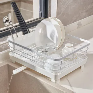 White kitchen dish drying rack with utensil holder and drain spout for bowls and plates.