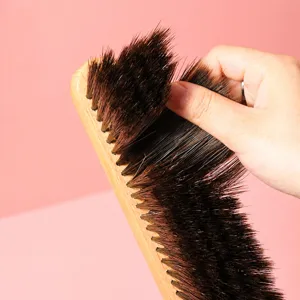 Wooden bed cleaning brush with soft brown bristles, ideal for household dust removal and tidy bedding.