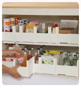Detail view of white expandable kitchen cabinet organizer box inside a pantry cupboard