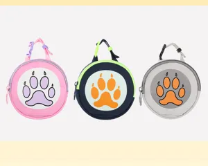 Close-up of portable pet waste bag dispensers and treat pouches featuring cute paw prints.