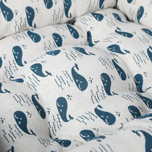 Close up detail of linen pet bed with cute blue whale pattern, soft and comfortable fabric.