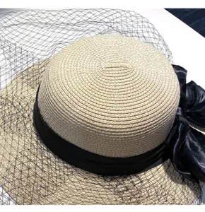 Closeup of women straw sun hat detail, black ribbon bow and vintage mesh veil decoration