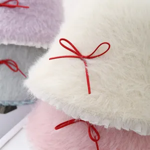 Kuscheliger Plüsch-Bucket-Hat im Detail, warme flauschige Wintermütze mit roter Schleife.