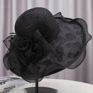 Detailed view of elegant black wide-brim sun hat with delicate lace floral decoration.