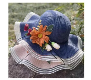 Detailaufnahme des Strohhats mit breiter Krempe, Blumenmuster und Netzrand fuer sonnige Tage.