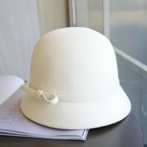 Close-up detail of a white wool felt bucket hat featuring a delicate side bow, elegant style.