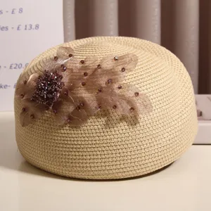 Detailaufnahme des Damensommer-Strohhutes mit eleganter Blumenapplikation und Strasssteinen.