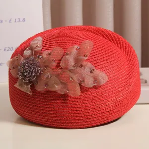 Nahaufnahme der roten Strohbaretto mit eleganter Mesh-Strassblumen-Dekoration im Sommer.