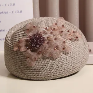 Nahaufnahme des Strohberets mit Mesh-Blume und funkelnden braunen Strasssteinen im Retro-Stil.