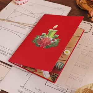 Close up detail of red 3D pop up Christmas greeting card with candle and poinsettia.
