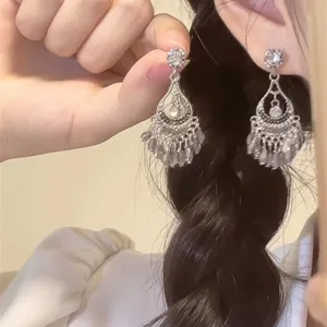 Λεπτομερές κοντινό πλάνο από boho vintage κρυστάλλινα κρεμαστά σκουλαρίκια με κρόσσια.