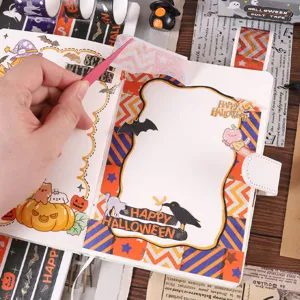 Gros plan de ruban adhésif washi doré Halloween et d'autocollants mignons sur un carnet.