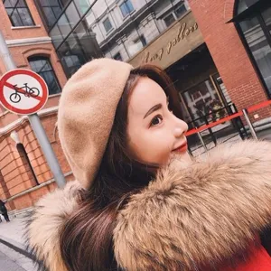 Detailed view of the stylish camel wool beret in an outdoor setting, highlighting fine texture.
