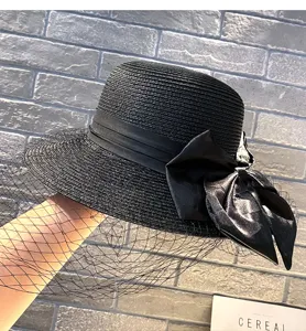 Black straw hat with elegant satin bow and mesh veil for women sun protection.