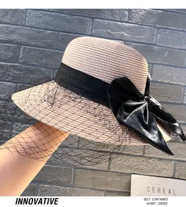 Detail view of summer Hepburn style straw hat with black mesh veil and elegant bow.