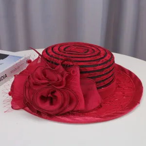 Detail shot of the vintage red flat top hat featuring elegant black lace and large roses.