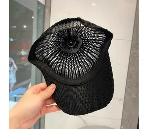 Vue detaillee de l interieur de la casquette de baseball noire en tricot creux.