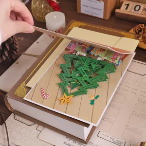 Close-up detail of 3D pop-up Christmas tree greeting card with intricate hollow paper design.
