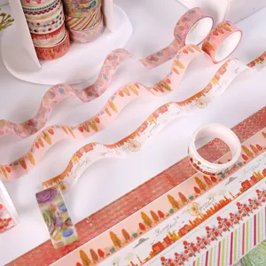 Decorative washi tape rolls featuring gold foil autumn tree and city designs for journaling.