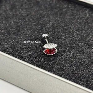 Exquisite seashell stud earrings featuring a red glass ball, stylish metal jewelry detail.
