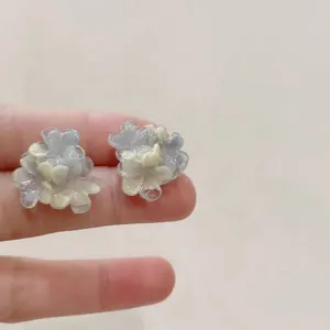 Close-up detail of gradient blue flower stud earrings, showing exquisite resin translucent texture.