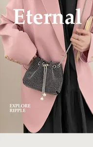 Close-up of black rhinestone drawstring bucket bag with pearl tassels and chain strap