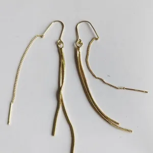 Detail view of long gold chain tassel earrings, elegant and stylish jewelry accessory.