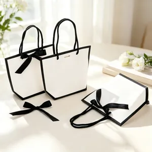 Elegants sacs cadeaux en papier blanc avec nœuds ruban noirs, emballage de luxe.