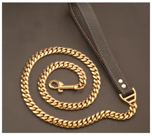 Close-up of heavy gold Cuban link dog leash with black leather handle and metal snap hook.