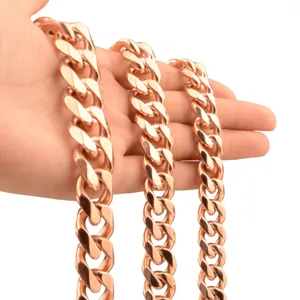 Close-up detail of rose gold stainless steel Cuban link chain held in hand for men.