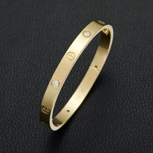Gold plated metal rhinestone screw bangle bracelet luxury fashion jewelry detail shot